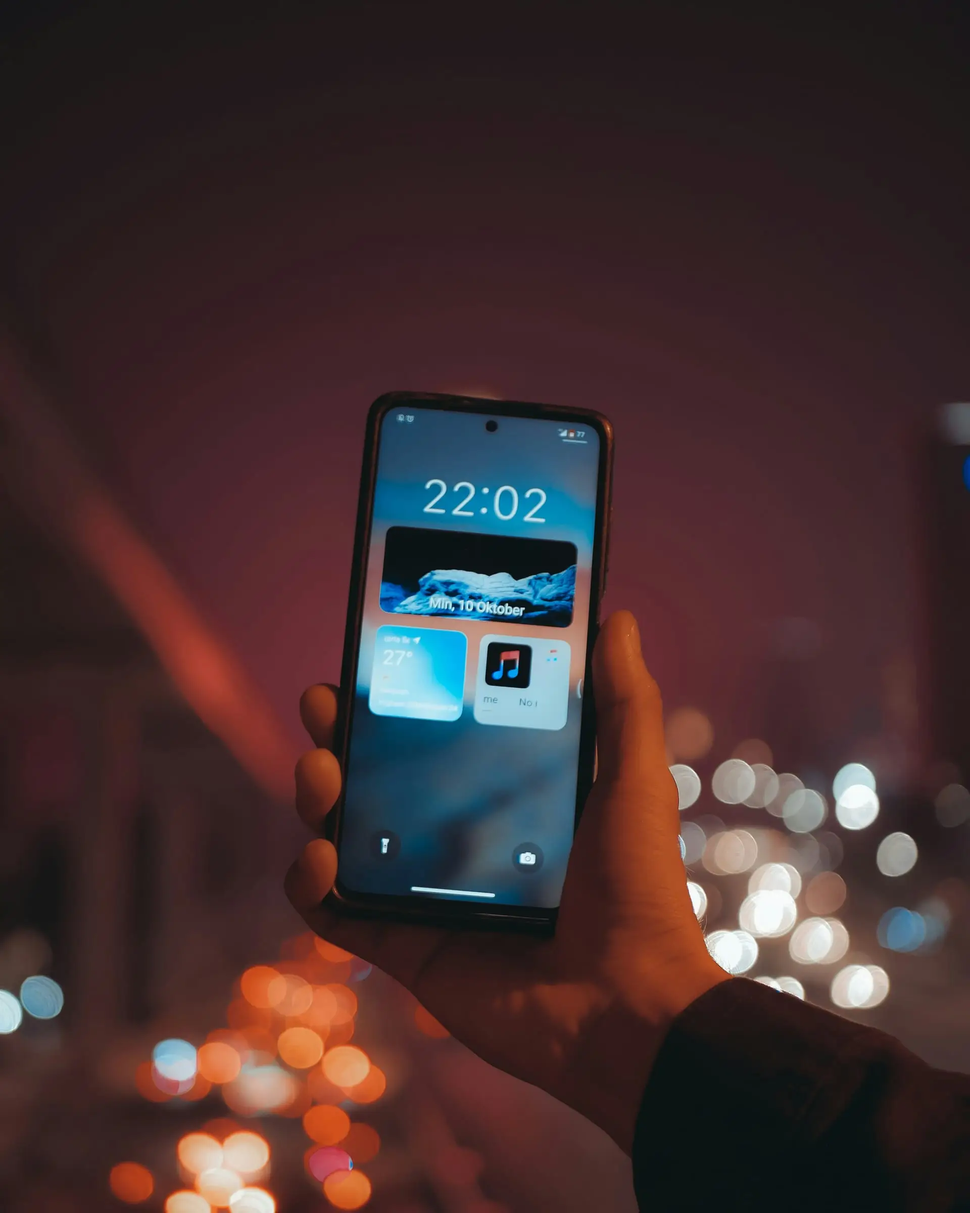 Hand holding a smartphone at night