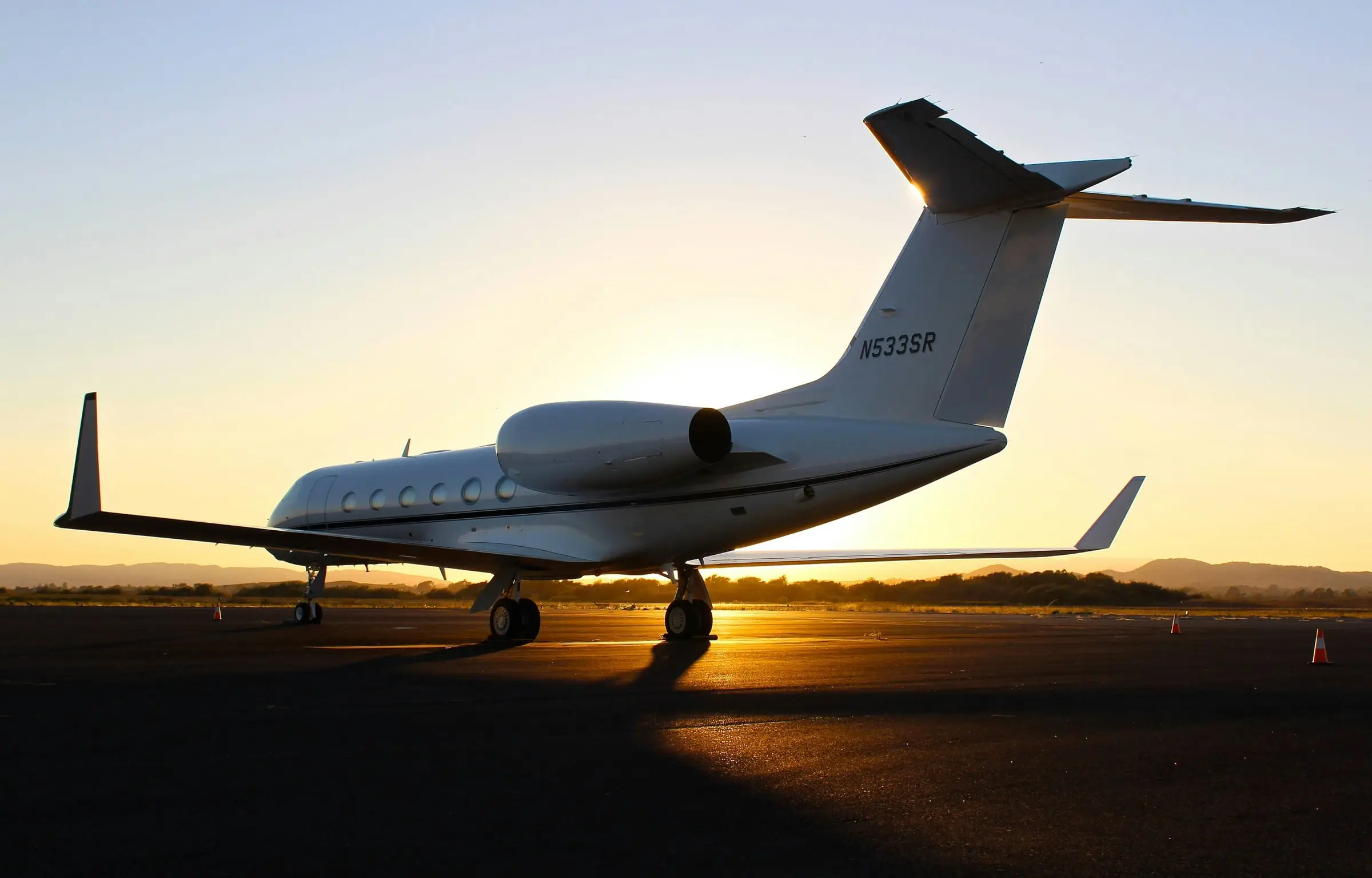 Business jet parked on an airfield at sunset