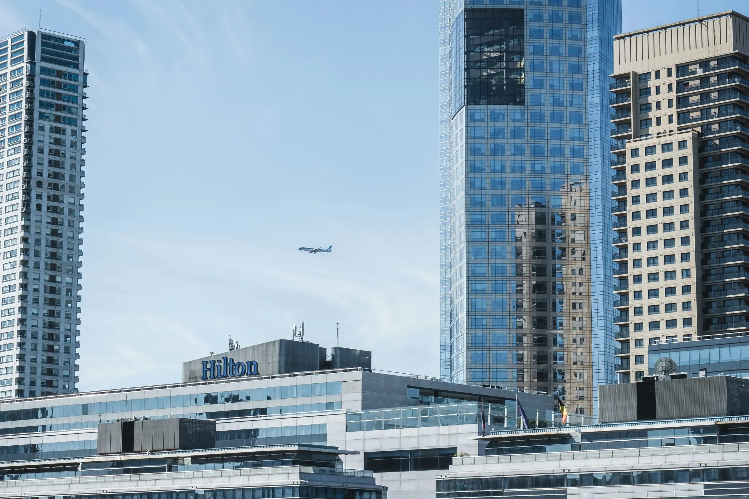Airplane flying between Buenos Aires high-rise buildings