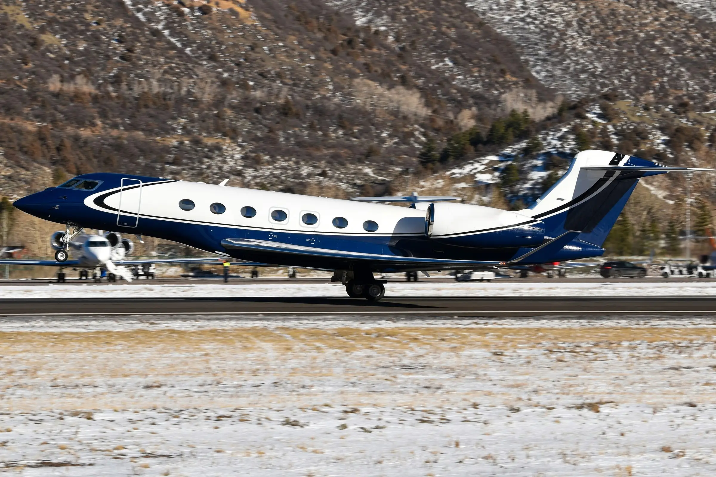 Large-cabin business jet on a runway with snow along the edges