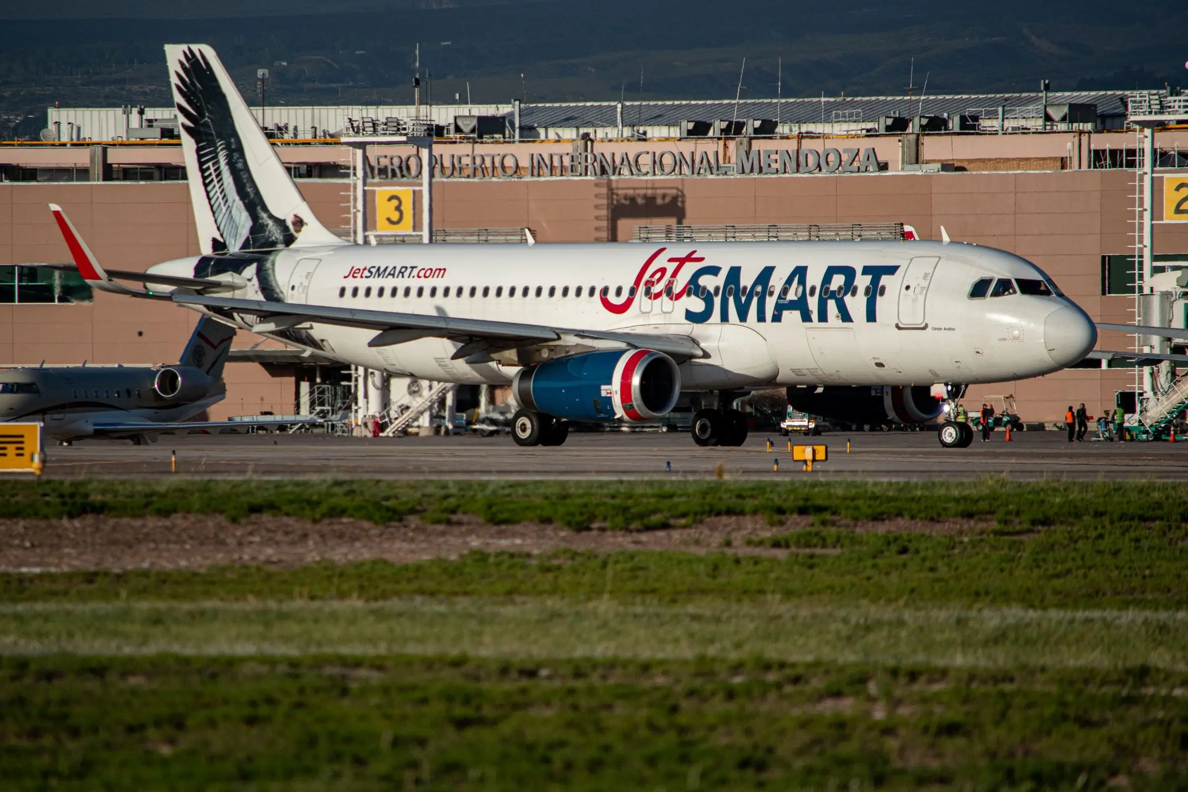 Avión de línea y un jet ejecutivo en la plataforma frente a la terminal del Aeropuerto Internacional de Mendoza