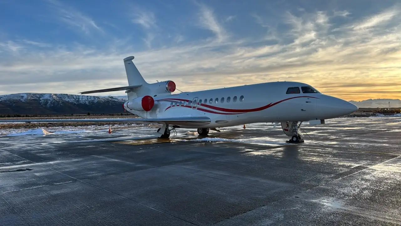 Jato executivo Falcon estacionado no pátio de Bariloche com morros nevados ao fundo