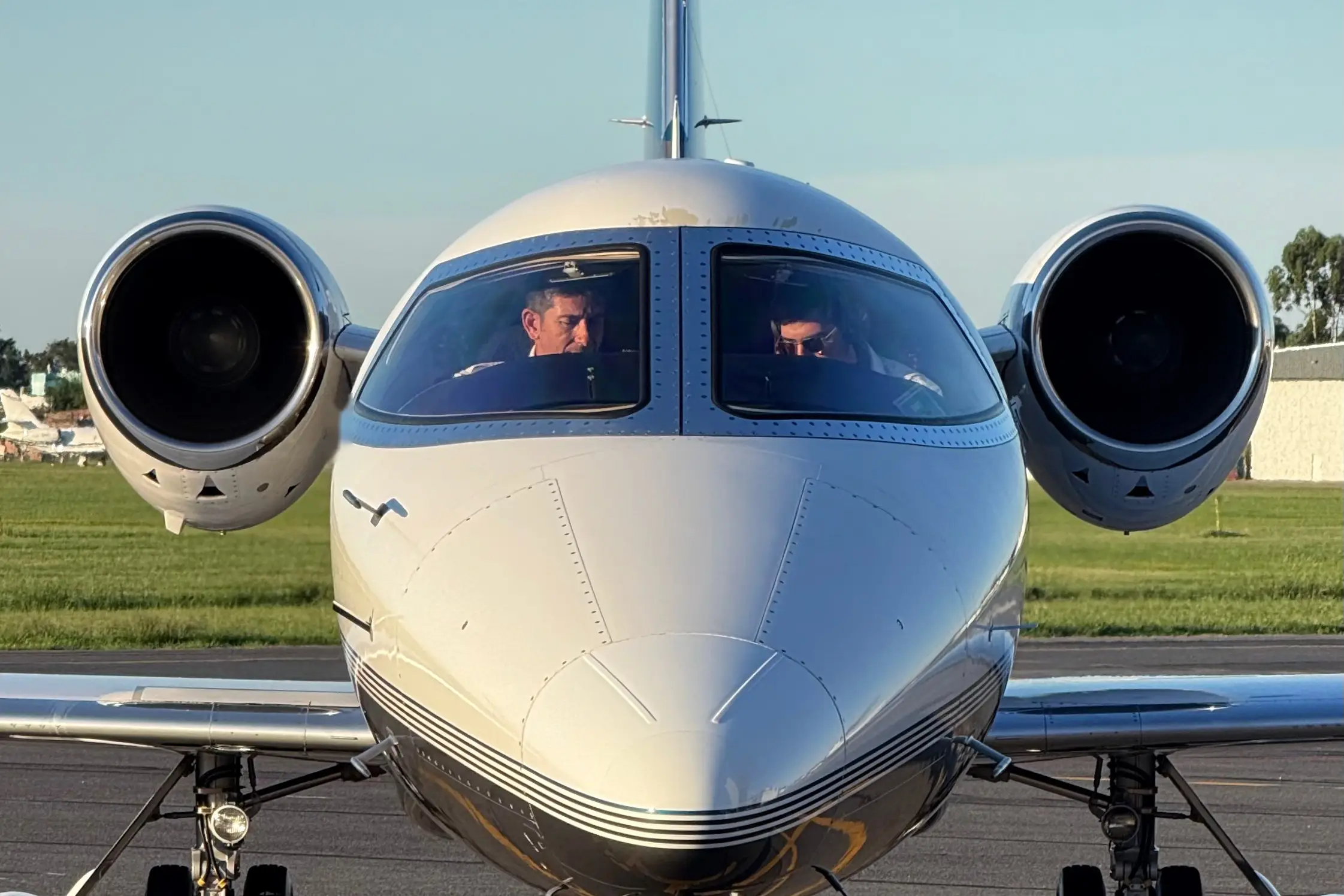 Front view of a business jet taxiing at San Fernando, with the crew in the cockpit