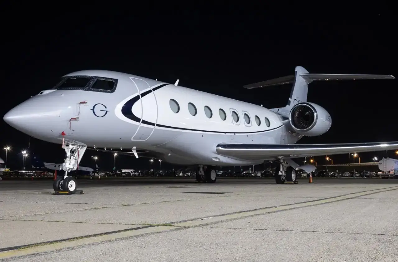 Jato executivo Gulfstream de cabine ampla estacionado no pátio à noite