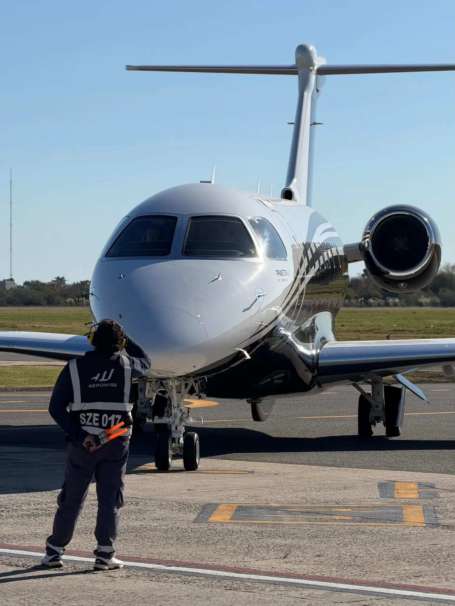 Aerowise ramp agent marshalling a business jet at San Fernando