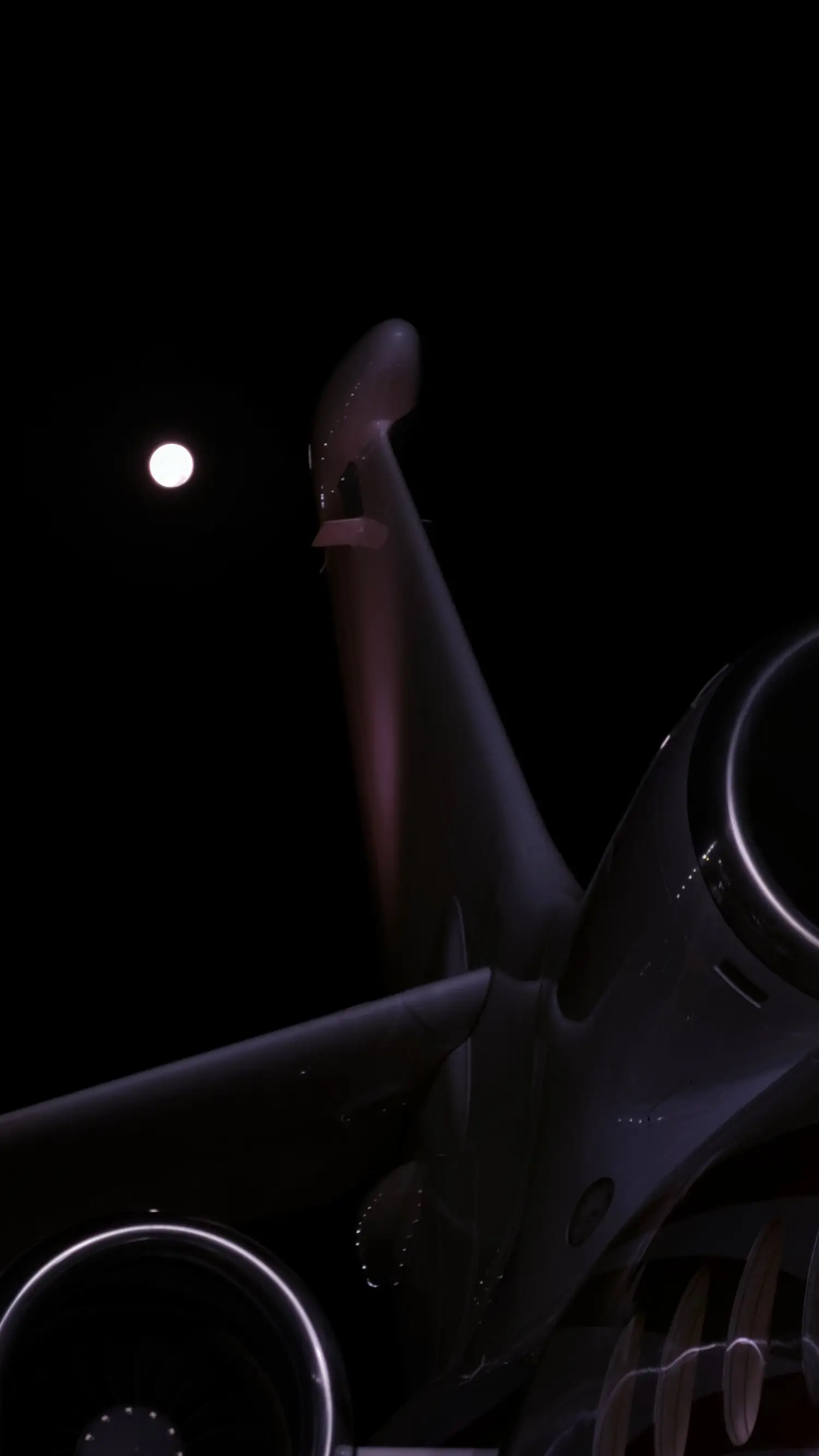 Cauda e motores de um jato executivo à noite no pátio do Aeroparque, com a lua cheia ao fundo