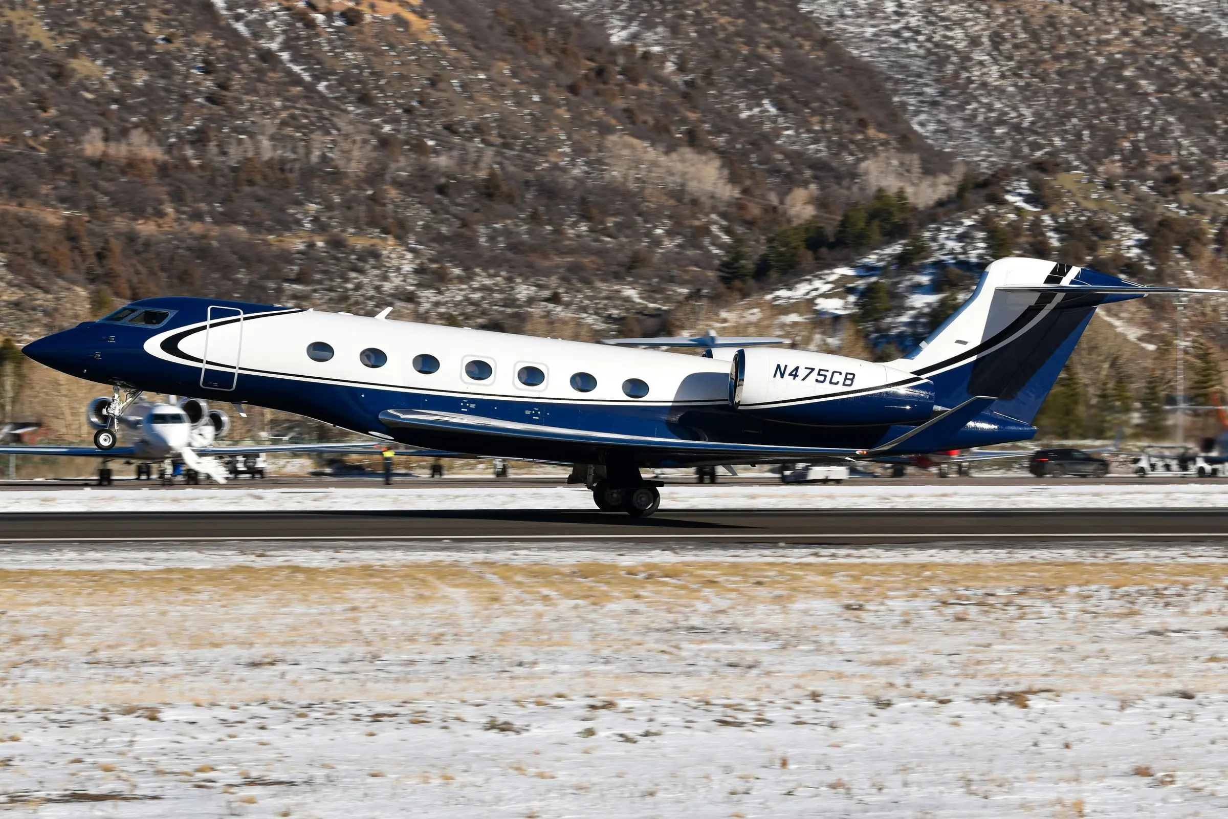 Large-cabin business jet on a runway with snow along the edges