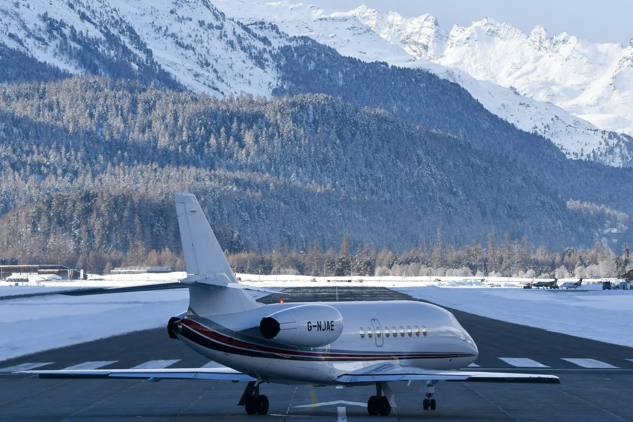 Business jet on an apron with snowy mountains behind it