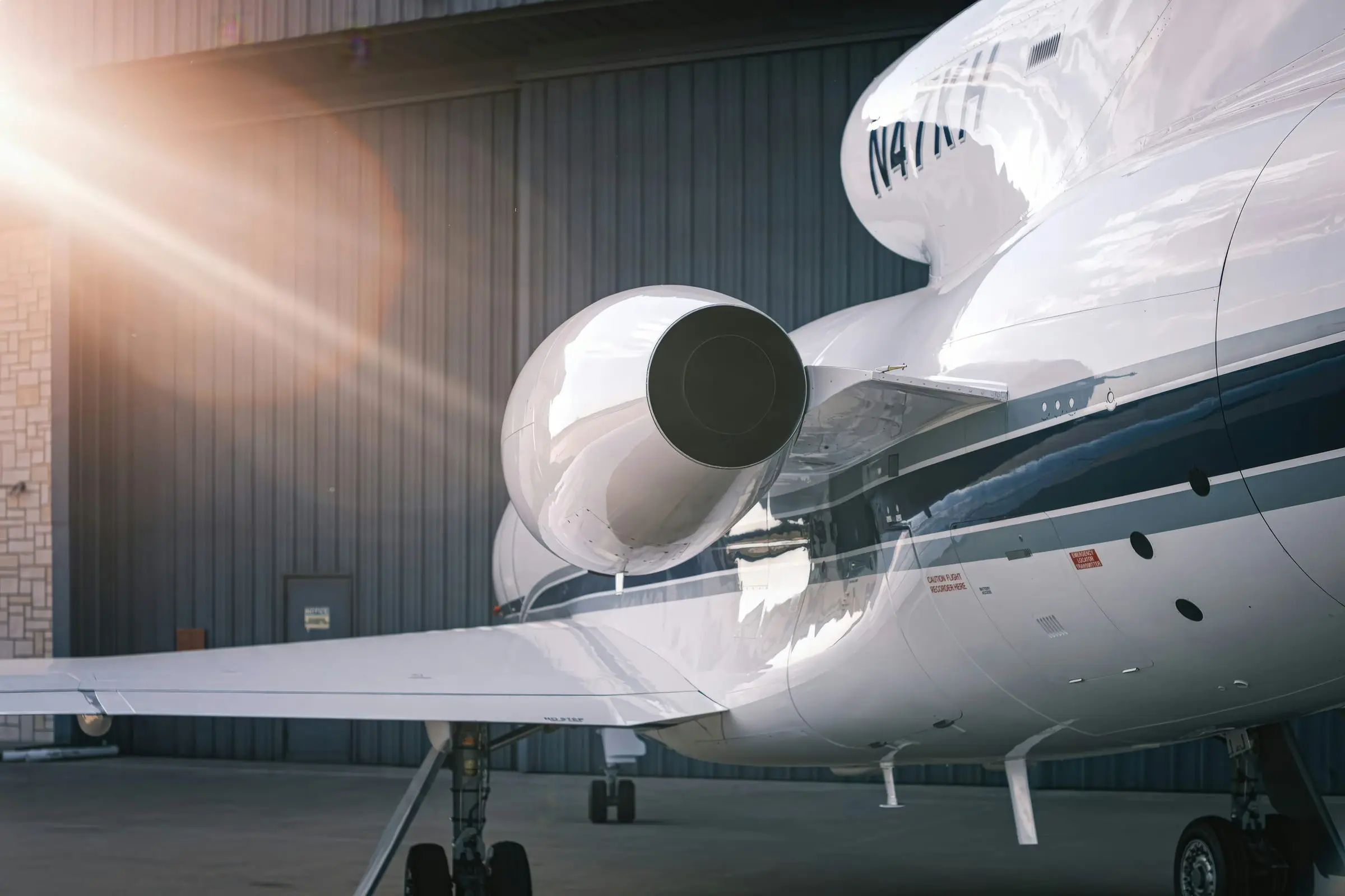 Rear fuselage and engine of a business jet outside a hangar